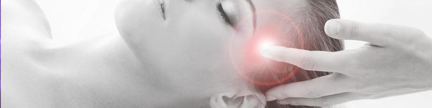 hand touching a person's head as they relax on a therapy table